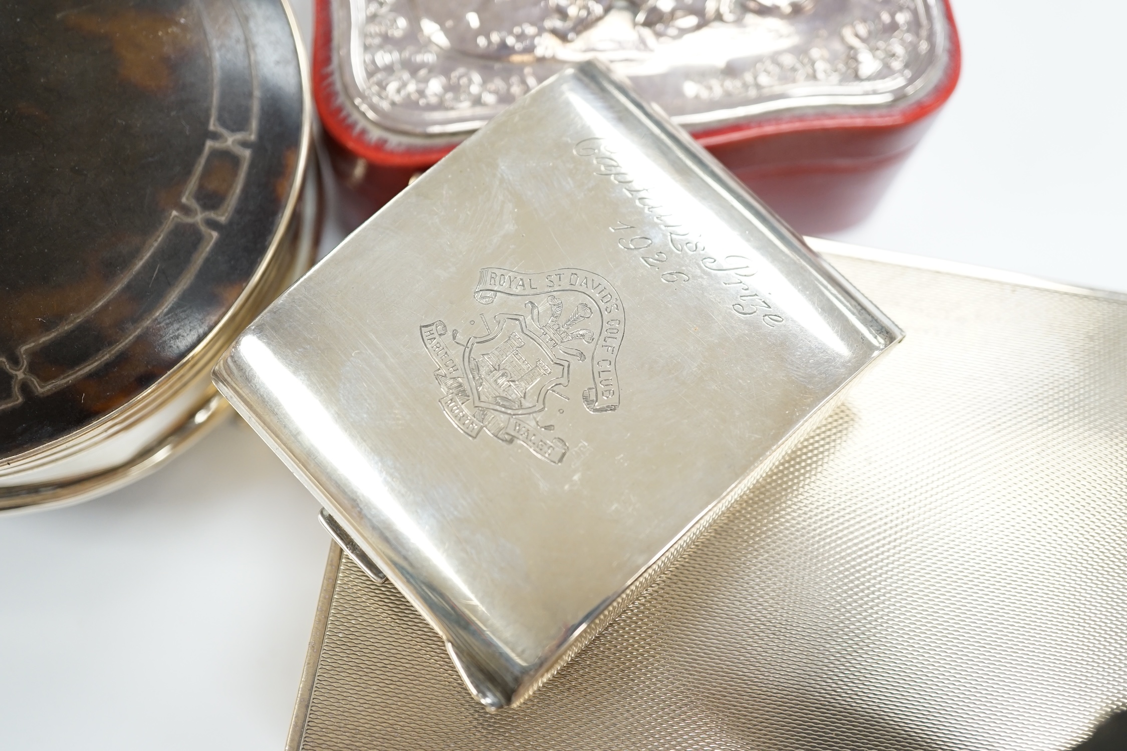 A George V silver and tortoiseshell mounted circular trinket box, Birmingham, 1923, 10cm, a silver cased travelling timepiece and two other silver mounted boxes including cigarette box.